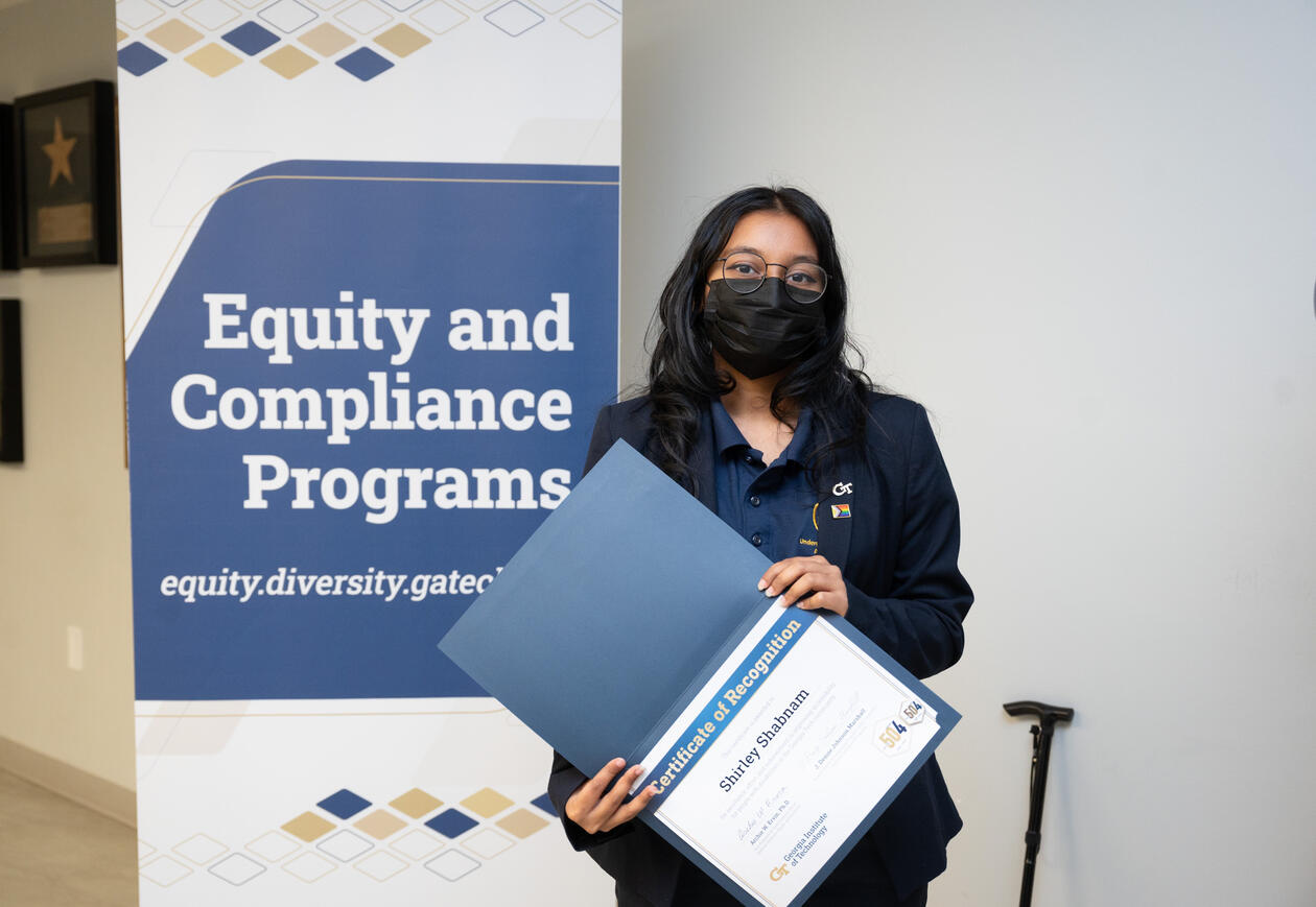 A picture of Shirley holding the certificate of Advocate for Accessibility Award